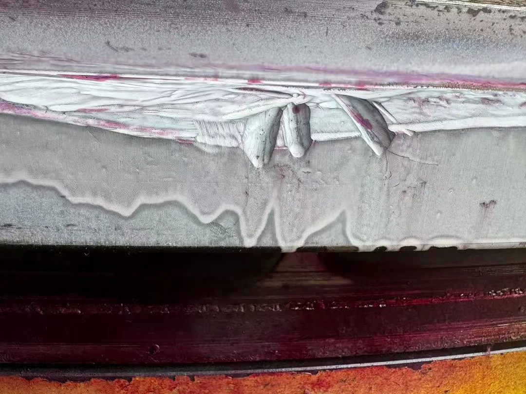 Close-up magnetic particle inspection showing severe discontinuities in bearing ring material.