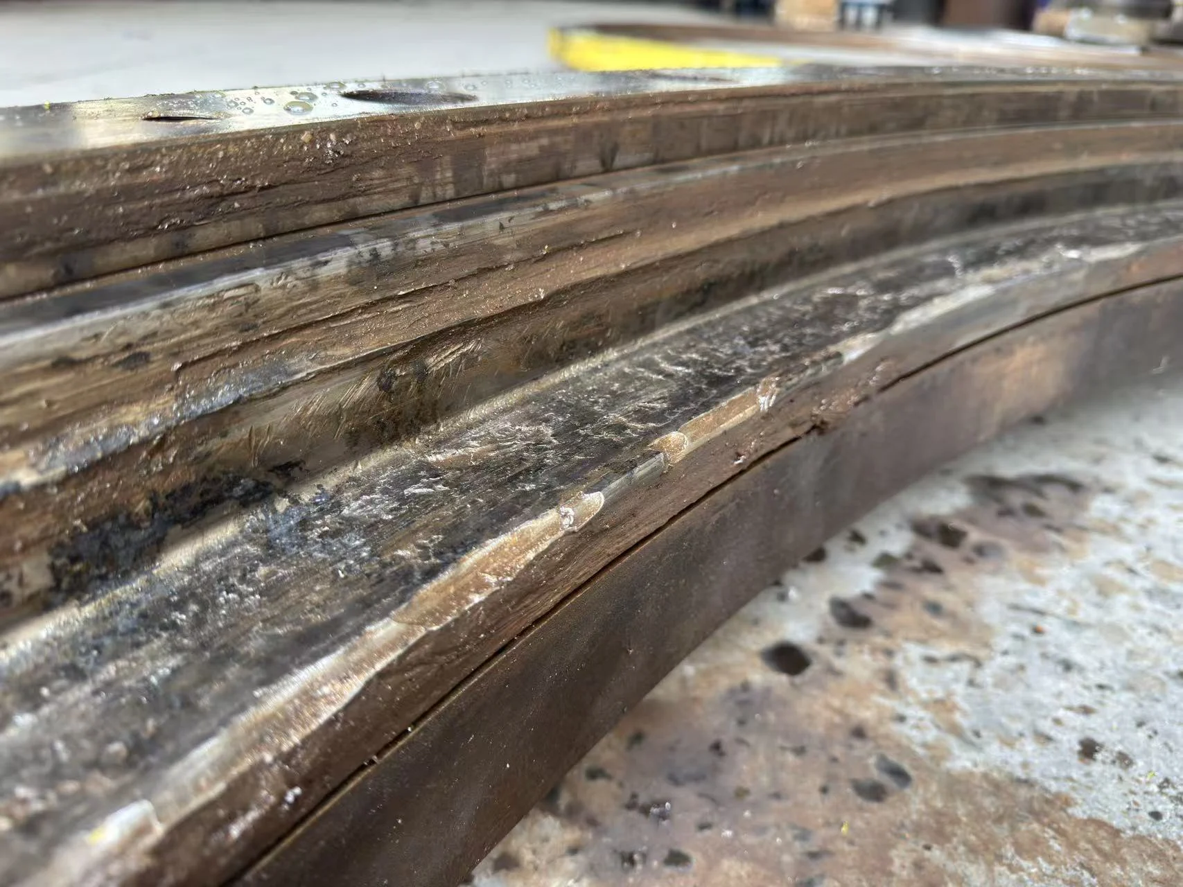 Close-up of severe wear, debris damage and deformation on a slewing bearing raceway.