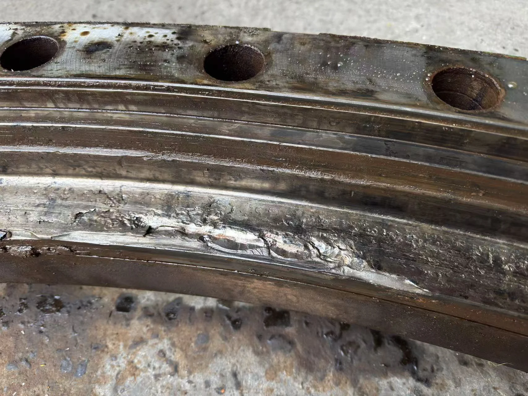 Severe spalling and material displacement on a port crane slewing bearing raceway.