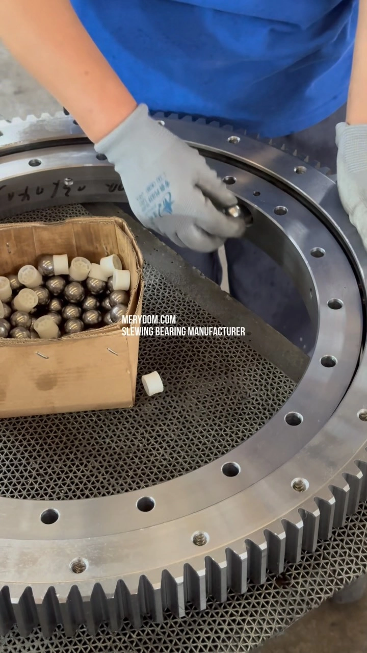 A single-row ball slewing bearing with external gear teeth is being assembled.